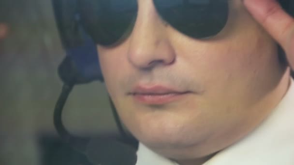 Piloto machista usando óculos de sol sentado no cockpit, capitão de avião, trabalho legal — Vídeo de Stock