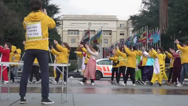 GENÈVE, SUISSE - CIRCA JANVIER 2016 : Étudiants coréens en tournée pour la paix en Europe. Personnes actives dansant symboliquement près du Bureau des Nations Unies, liberté d'expression — Video