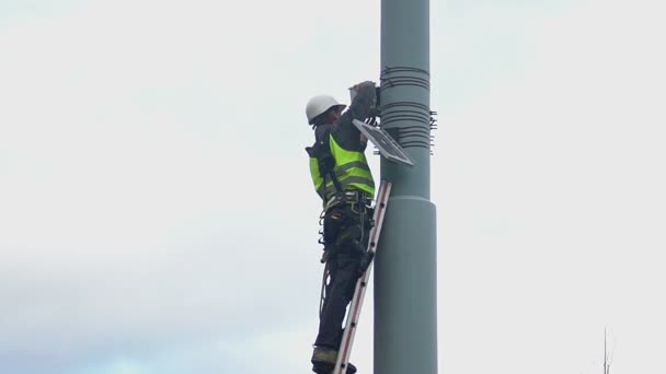 Kommunala ingenjör stående på stege på höjd, farliga underhållsarbete — Stockvideo