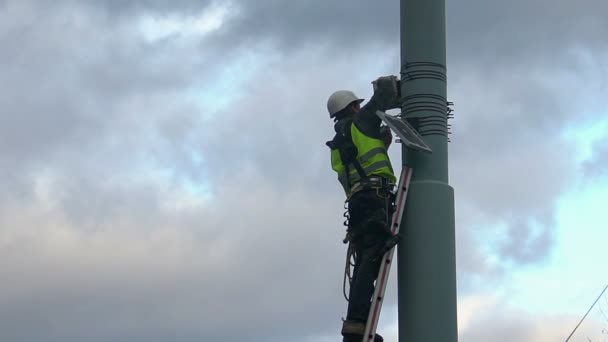 Maintenance worker servicing street video surveillance system, work at height — Stock Video