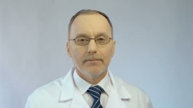 Kameraya bakan erkek hekimin nazik gülen yüzü, sağlık hizmetleri