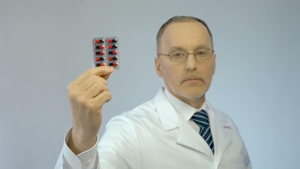 Jistý terapeut drží balíček prášků, doporučit účinné léky — Stock video