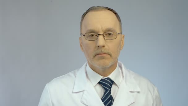 Poważny mężczyzna lekarz przedstawiający strzykawkę i ampułkę, gotowy do wstrzyknięcia szczepionki — Wideo stockowe