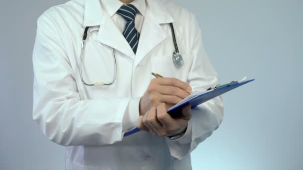 Medico professionista che scrive in documenti cartacei, conservando le cartelle cliniche — Video Stock