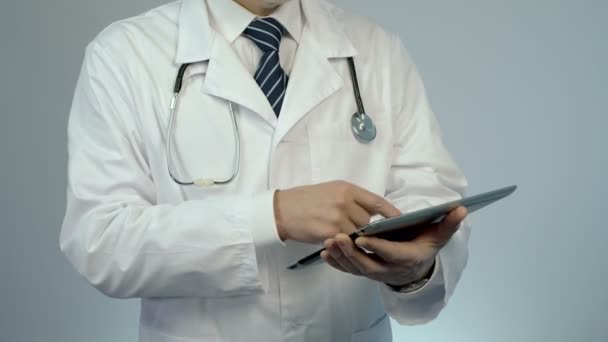 Terapeuta que usa tableta PC para comprobar la historia clínica del paciente o los resultados de las pruebas de laboratorio — Vídeos de Stock