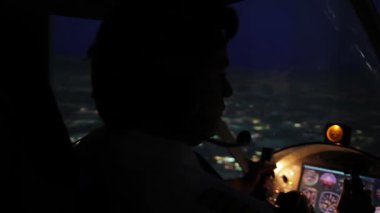 Akşam şehir, yorgun baş pilot uçak karanlık kabinde direksiyon üzerinde uçuş