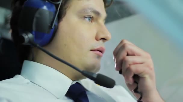 Hezký pilot mluvit řídícího letového provozu, zatímco letí letadlo, pracovních povinností — Stock video