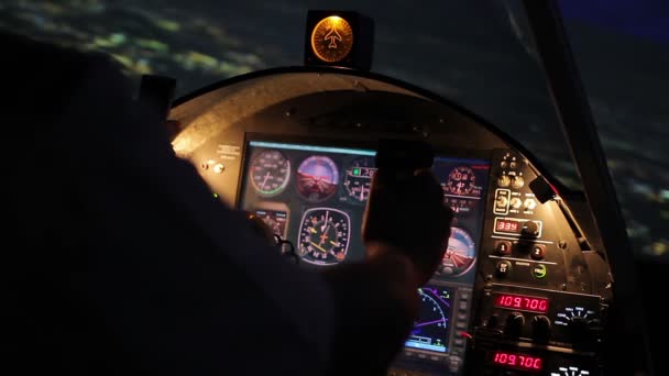 Pilot's hands on steering wheel, night flight, airplane hovering above city — Stock Video
