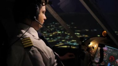 Profesyonel uçak mürettebatı komutan şehir üzerinde uçak gece anda gezinmek