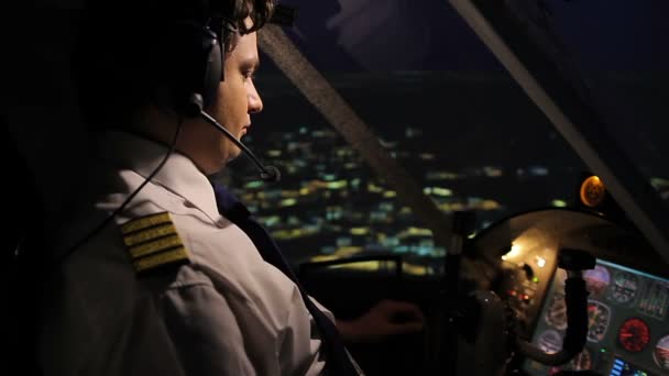 Professioneller Flugzeugführer, der nachts Flugzeuge über der Stadt steuert — Stockvideo
