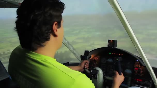 Joven macho sentado en la cabina, disfrutando de vuelo en simulador de avión, hobby — Vídeos de Stock