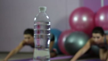 Tatlı su şişe için spor salonunda germe esnek kadından değişen odak