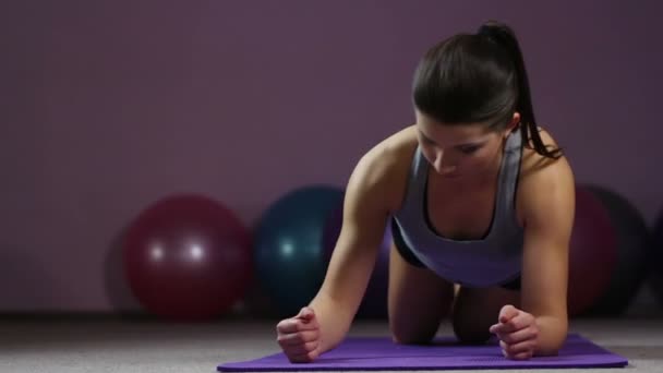 Mujer joven que toma la posición de retención frontal, trabajando duro en el gimnasio para tener el cuerpo en forma — Vídeo de stock