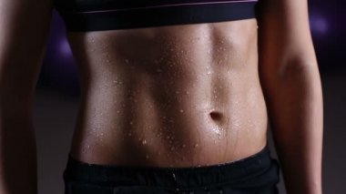 Spor salonunda eğitim sportif kadının ideal düz karın aşağı dökülen su damlaları