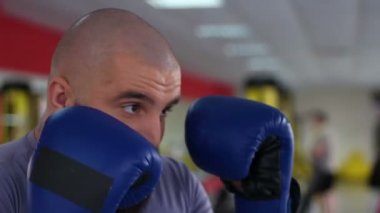 Boks eldivenleri ortak fikir tartışması egzersiz sırasında Delme erkekte yüz closeup