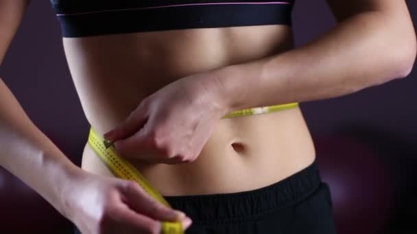 Vrouwelijke platte buik close-up, vrouw met behulp van meetlint te tonen van weightloss resultaat — Stockvideo