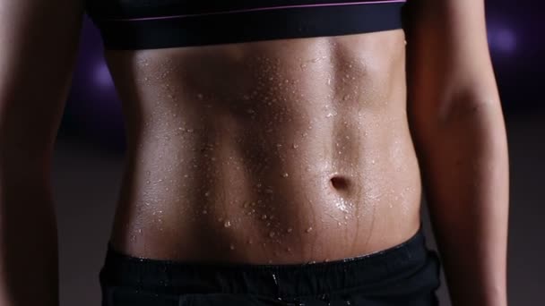 Gotas de agua derramando el vientre plano ideal de entrenamiento de mujer deportiva en el gimnasio — Vídeos de Stock