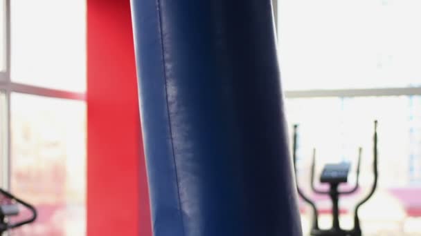 Homem enérgico chutando saco de boxe com perna, boxeador forte trabalhando no ginásio — Vídeo de Stock