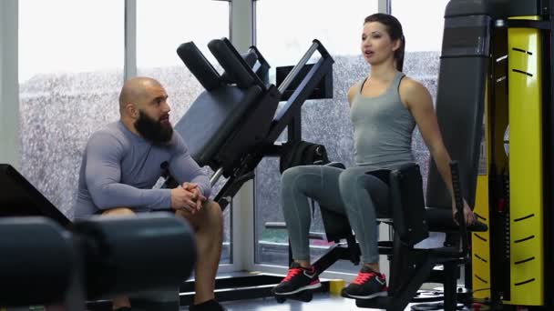 Mujer joven activa entrenando en el gimnasio, hablando con un hombre deportivo guapo, choca los cinco — Vídeos de Stock