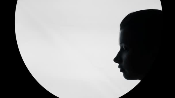 Silhouette of beautiful young woman with finger on lips, keep silence gesture — Stock Video