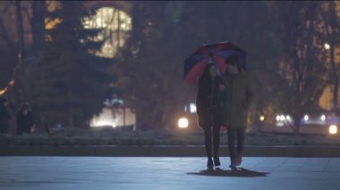 Kız arkadaşı ve erkek arkadaşı birlikte yürüme, kız şemsiye tutan, romantik tarih