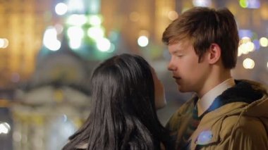 Sevgi dolu çift öpüşme ve sarılma, gece şehir bakarak, romantik tarih zevk