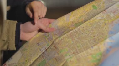 Erkek ve kadın elleri şehir haritasını tutan ve sokak arama, turizm, yakın çekim