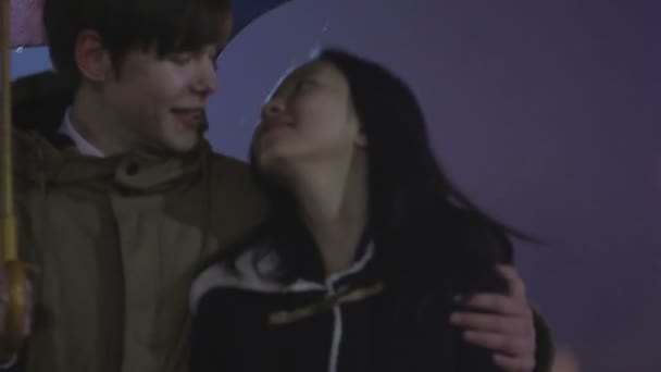 Couple doux flânant avec parapluie, parlant de week-end, visites de la ville 