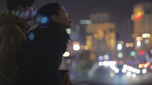 夜の市内中心部、ロマンチックな夜景を楽しんでいる甘いティーンエイ ジャーのカップル — ストック動画