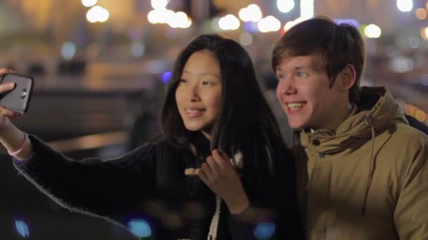 Grappige jongen en meisje het maken van selfies op smartphone en genieten van weekend, tijdig — Stockvideo