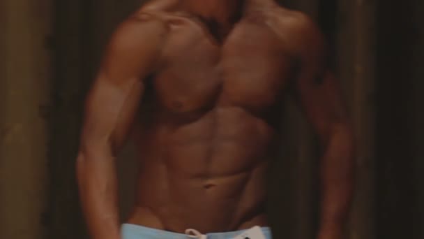 Strong male bodybuilder posing at competition, showing ideal ripped six-pack abs — Stock Video