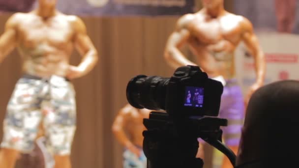 Uomo fotografare atleti muscolosi in competizione al campionato di bodybuilding — Video Stock