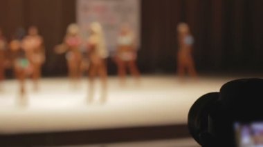 Sahne Alanı'nda güzel fitness modelleri fotoğraflarını fotoğrafçının kamera tuşuna basın