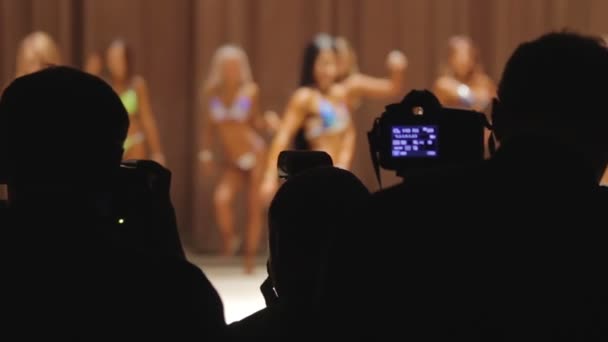 Muitos fotógrafos usando câmeras para tirar fotos no concurso de beleza fitness — Vídeo de Stock