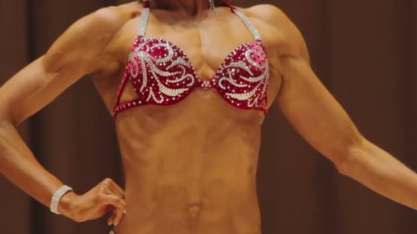 Bodybuilderinnen demonstrieren fitte Körper in glitzernden Badeanzügen bei Contest — Stockvideo