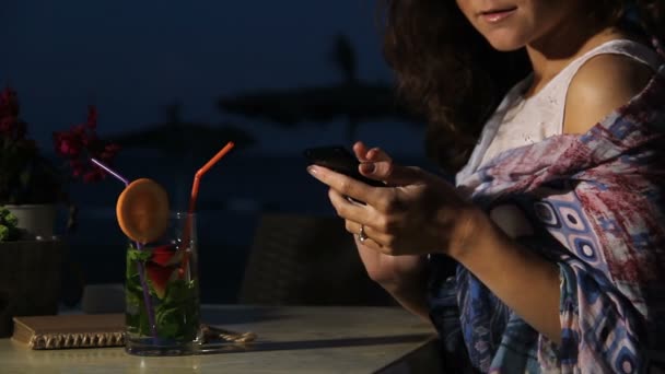 Lächelnd hübsche Brünette Senden von Nachricht an Freund auf Handy, Chat — Stockvideo