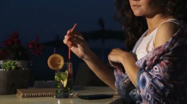 Esmer kadın sahil kafe, dinlenme sahip kokteyl, zevk gece içme