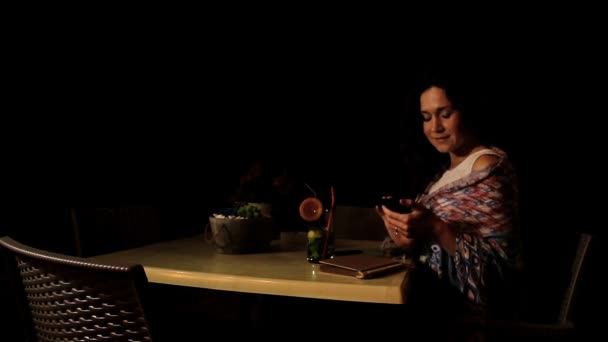Glückliches brünettes Mädchen telefoniert mit Freundin im Strandcafé, entspannter Abend — Stockvideo