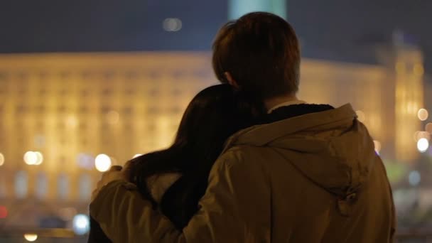 Beau couple s'embrassant amoureusement sur la date, profitant de la vue nocturne sur la ville — Video