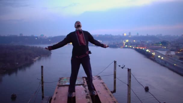 Jonge man staande bovenop de brug, op zoek naar de zin van leven, gevaar, vrijheid — Stockvideo