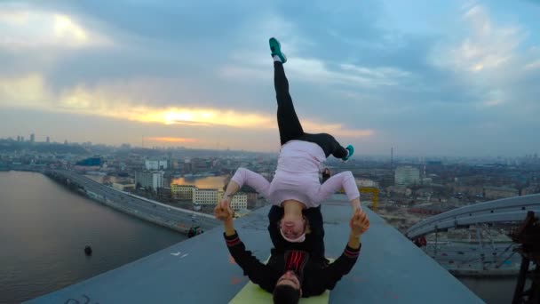 Habilidades profesionales, atletas haciendo acrobacias peligrosas en el puente, yoga acrobático — Vídeos de Stock