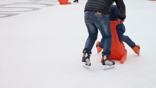 Muchos niños se divierten en la pista de patinaje, disfrutando del descanso activo en el hielo en invierno — Vídeos de Stock