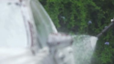 Temiz Oto, araç bakım servisi için tabanca sprey köpük ve su kullanan adam