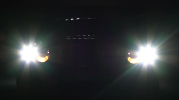 Car headlamps switch on and off in darkness, bright headlight illumination — Stock Video