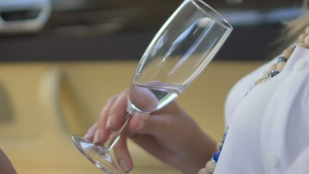 Nahaufnahme einer weiblichen Hand, die ein Glas Weißwein hält, eine entspannte Frau, die Ruhe genießt — Stockvideo