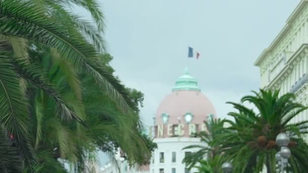 Luksusowy pięciogwiazdkowy hotel, Francuska flaga macha na dachu, piękne miasto architektura — Wideo stockowe