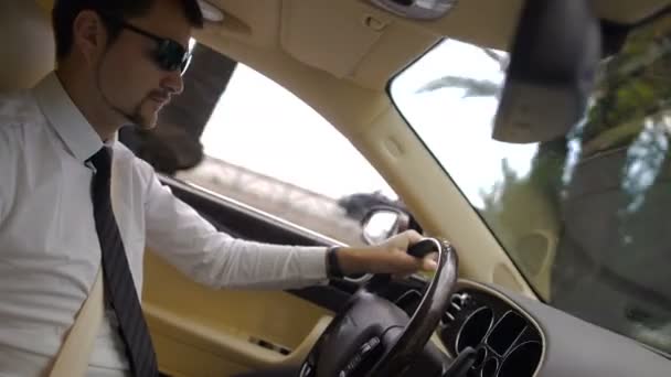 junger Geschäftsmann mit Sonnenbrille fährt cooles Auto, schöner Blick auf die Stadt