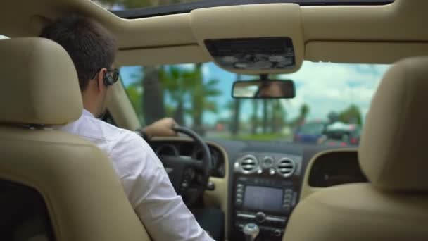 Hombre feliz en gafas de sol coche de conducción de vacaciones, mostrando los pulgares hacia arriba gesto de la mano — Vídeos de Stock