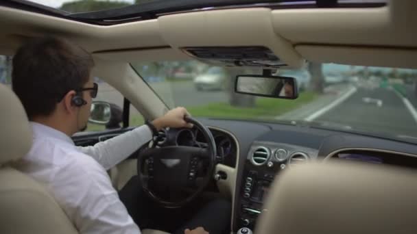 Успешный бизнесмен за рулем дорогого автомобиля спешит на работу, транспорт — стоковое видео