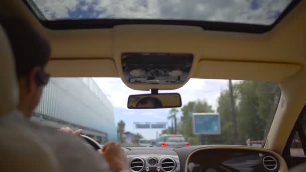 Chauffeur concentré conduisant une voiture de luxe dans la circulation urbaine, chauffeur d'affaires — Video